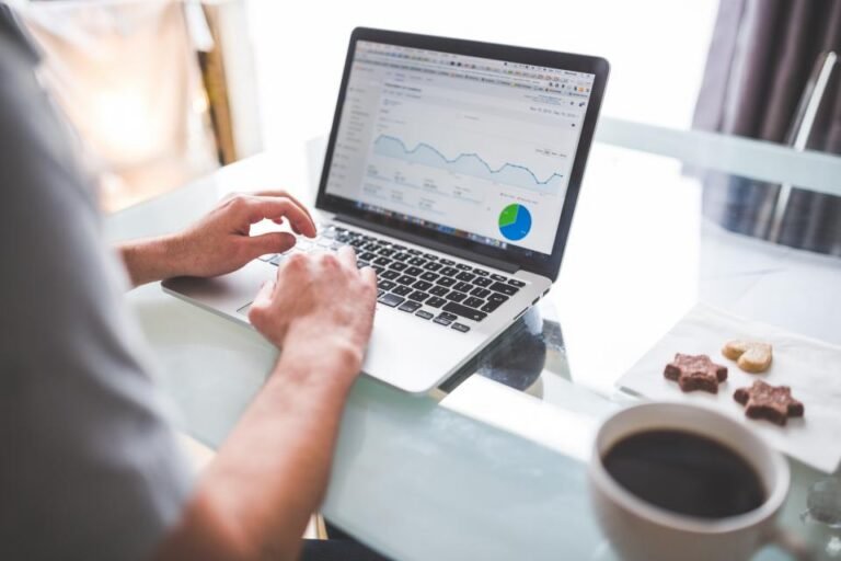 Mains sur un ordinateur portable affichant des graphiques statistiques