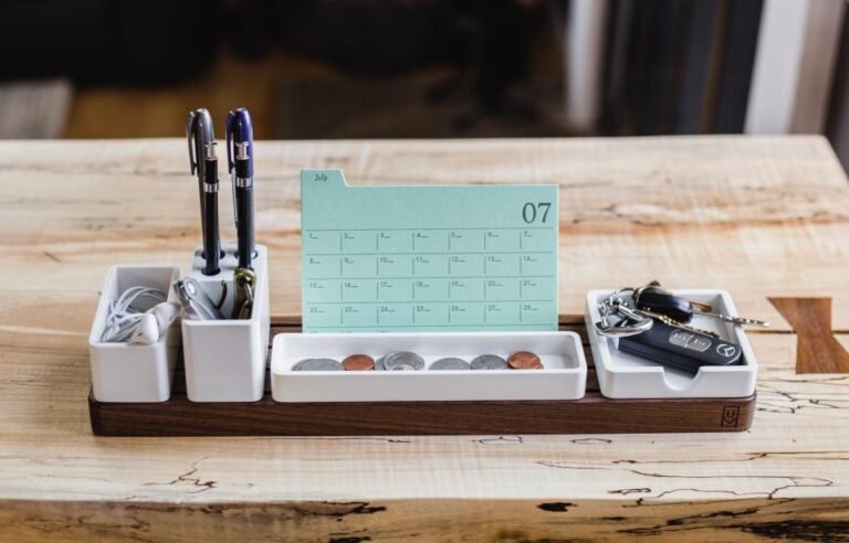 Calendrier de bureau posé sur un plateau en bois avec des stylos
