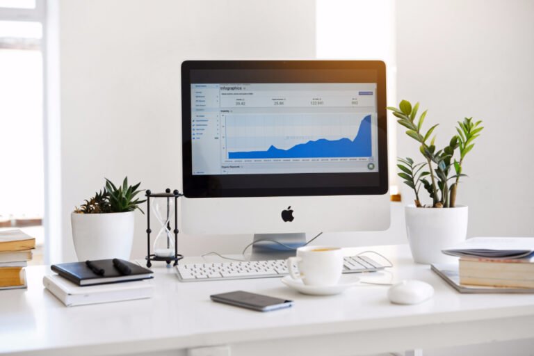 Ordinateur de bureau affichant une courbe de statistiques, sur un bureau clair
